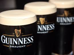 Three fresh pints of Guinness on the bar